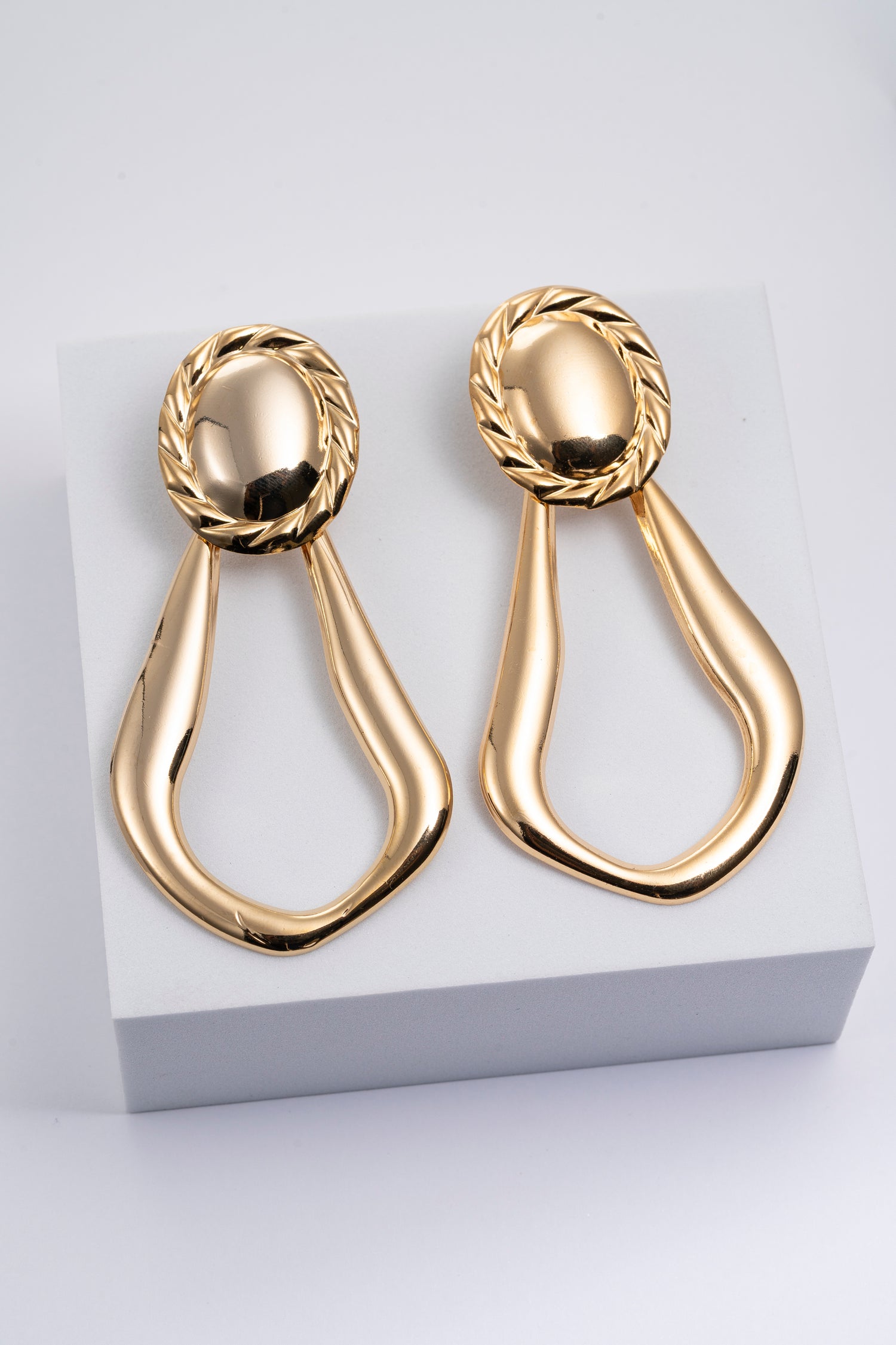 Orecchini dorati con motivo alloro e design scultoreo Domina