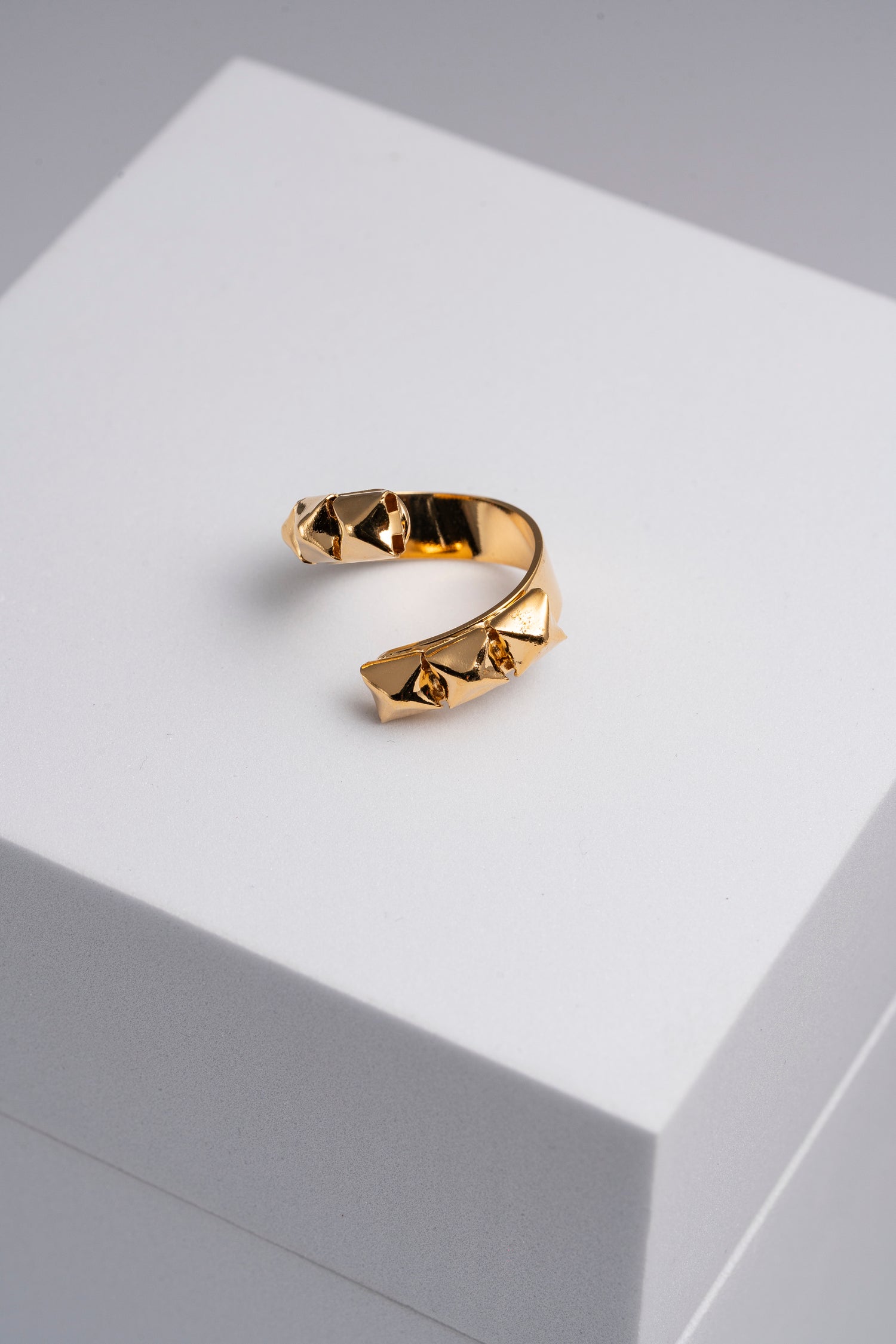 Anello dorato aperto con borchie scultoree Athena